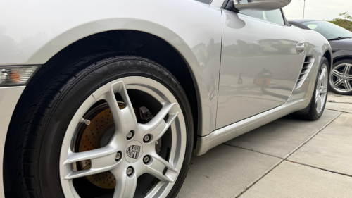 Low view of side of Porsche showing off the logo on the rims